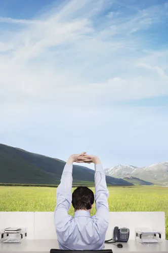 A man stretching his body in front of his work desk